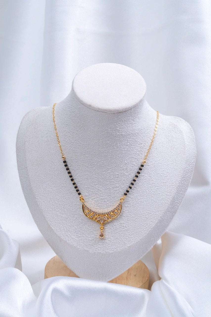 Traditional Filigree Crescent Mangalsutra flat lay on peach background - Nyara