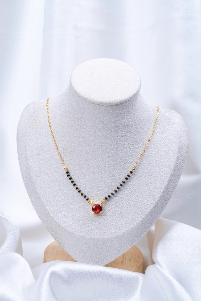 Ruby Red Solitaire Mangalsutra flat lay on peach background - Nyara