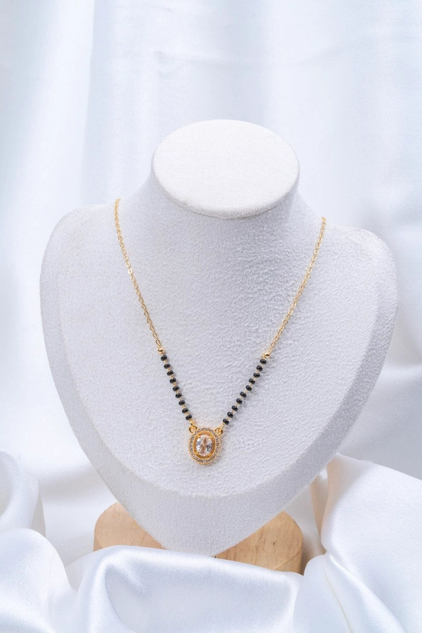 Oval Solitaire Diamond Mangalsutra flat lay on peach background - Nyara