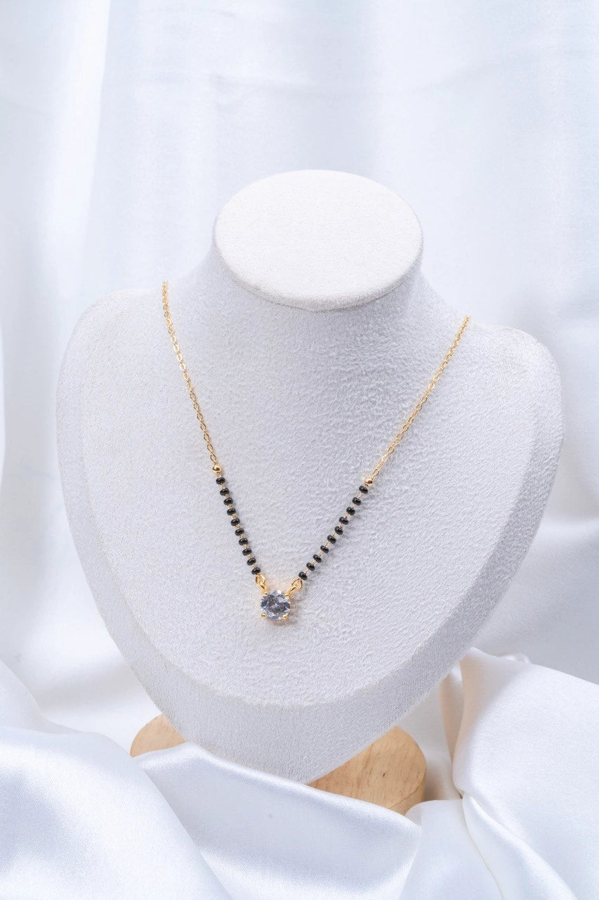Round Solitaire CZ Mangalsutra flat lay on peach background - Nyara