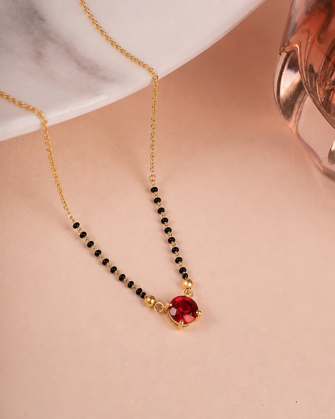 Ruby Red Solitaire Mangalsutra on jewellery stand - Nyara